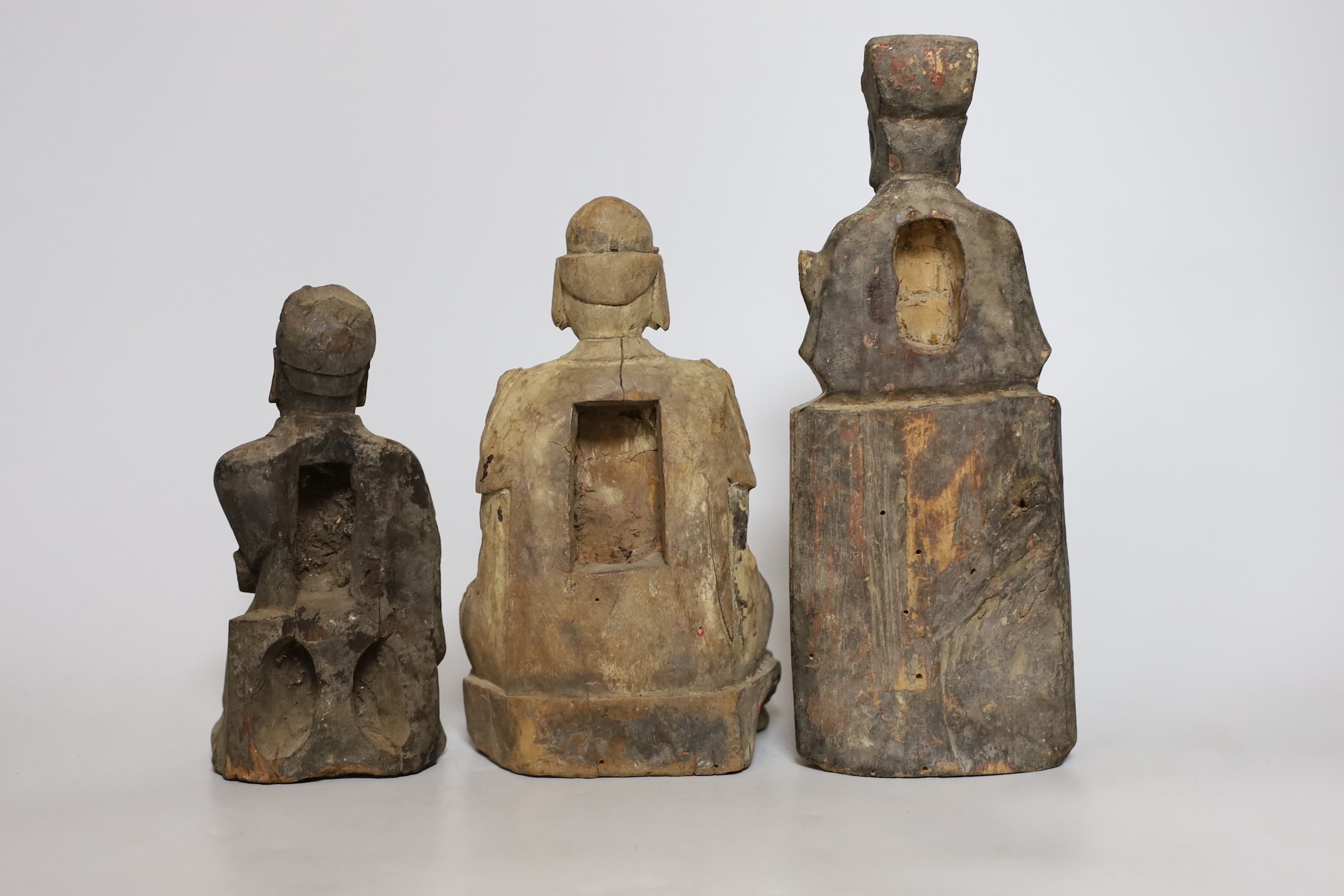 Three Chinese carved wooden figures seated immortals, Qing dynasty, Tallest 26cm